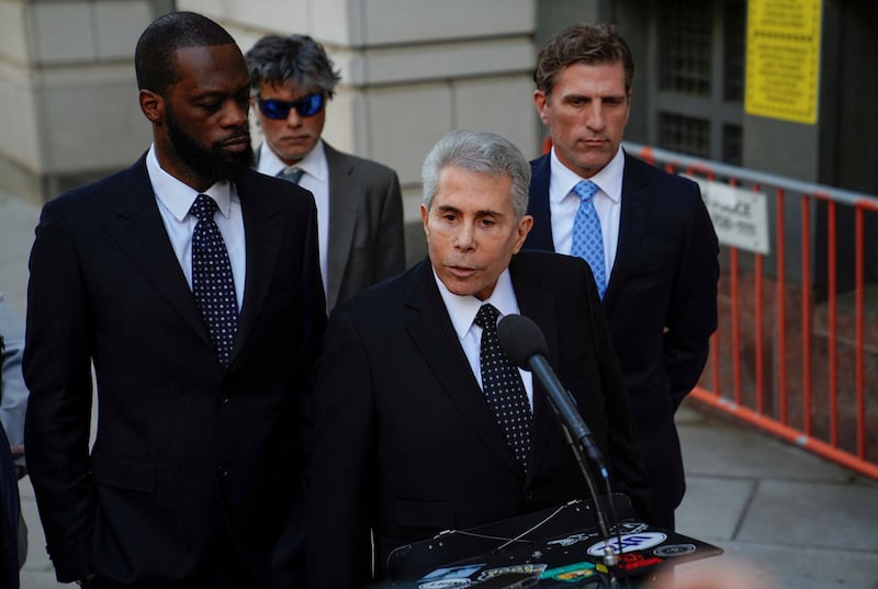 Pras Michel listens as his attorney David Kenner talks outside U.S. federal court after Michel was convicted on criminal charges