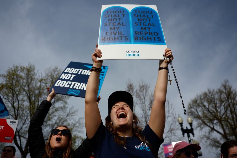 Photograph of people protesting outside the Supreme Court when they are hearing a case about mifeprestone used for abortions