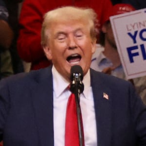 Donald Trump hands outstretched behind a lectern marked Trump-Vance