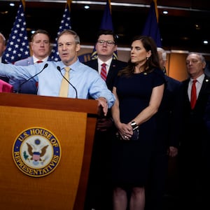 Republican House Members gather behind a podium for a press conference.