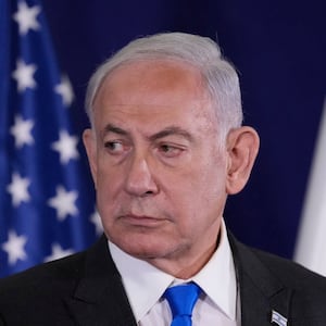 Israeli Prime Minister Benjamin Netanyahu looks on, pictured before flags.