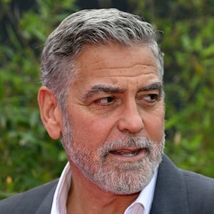 George Clooney stares to his left while at an outdoors event.