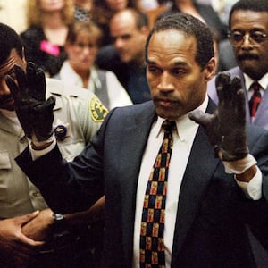 O.J. Simpson famously raises his hands as he puts on gloves in front of the jury during his double-murder trial.