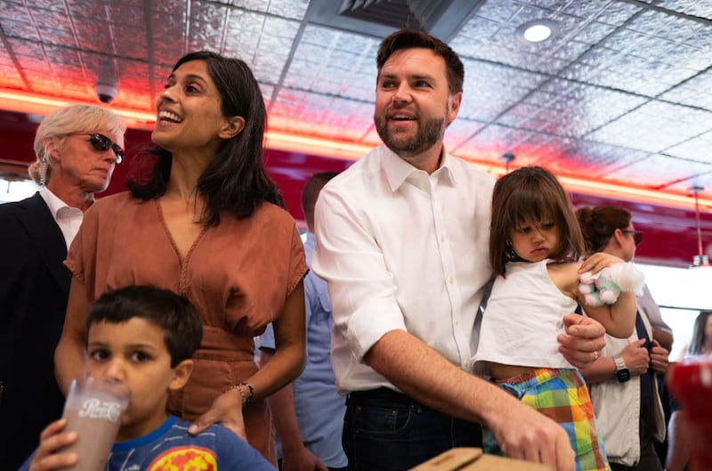 Republican vice presidential nominee J.D. Vance carries his daughter Maribel Vance as he and his wife Usha greet supporters at the Park Diner in St Cloud, Minnesota. 