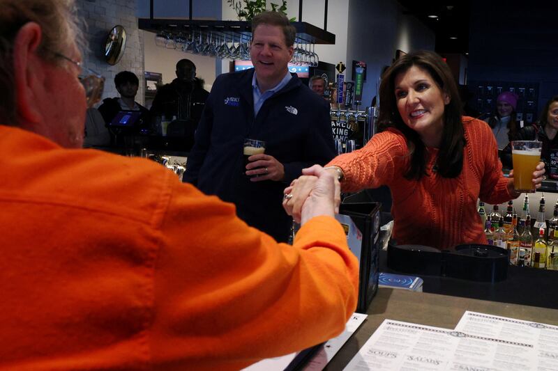 Nikki Haley and New Hampshire Governor Chris Sununu greet diners during a campaign stop at T-Bones ahead of the New Hampshire primary election in Concord, New Hampshire, January 22, 2024.