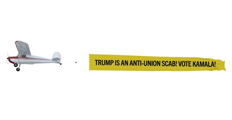 Small airplane flying a banner that says: Trump Is an Anti-Union Scab! Vote Kamala!