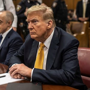 Donald Trump sits in a courtroom between his lawyers Emil Bove and Todd Blanche.