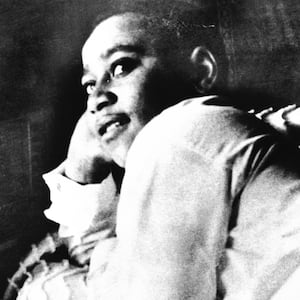 A photo including Emmett Till is shown lying on his bed.