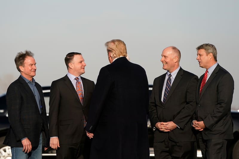 Donald Trump is greeted by U.S. Representatives from Michigan Bill Huizenga, John Moolenaar, and Jack Bergman, Michigan State Rep. Matt Hall and Former Michigan State Attorney General Bill Schuette during a 2019 trip to Grand Rapids, Michigan.