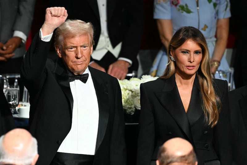 Former President Donald Trump raises his fist as he and his wife Melania Trump attend the 79th Annual Alfred E. Smith Memorial Foundation Dinner in New York City.