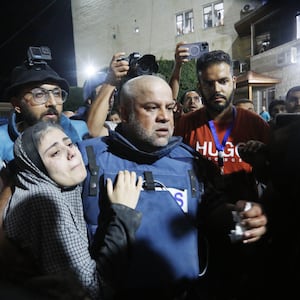 Al Jazeera reporter Wael al-Dahdouh carries his injured son from an ambulance to hospital in Gaza City.