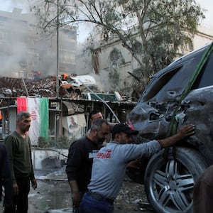 Rescue workers move near the scene of an airstrike in Damascus, Syria.