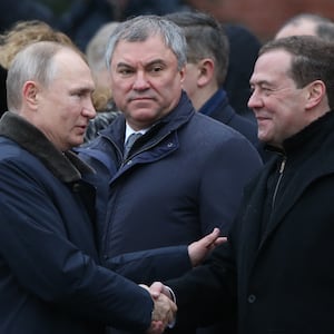 Russian President Vladimir Putin (L) greets Deputy Chairman of Security Council Dmitry Medvedev (R) as State Duma Speaker Vyacheslav Volodin (C) looks on.