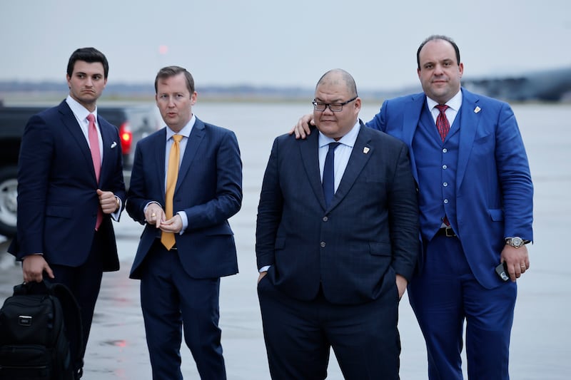 Trump campaign Communications Director Steven Cheung (2nd R) stand by as Republican presidential nominee Donald Trump speaks to reporters on the tarmac at Green Bay Austin Straubel International Airport on October 30, 2024 in Green Bay, Wisconsin.