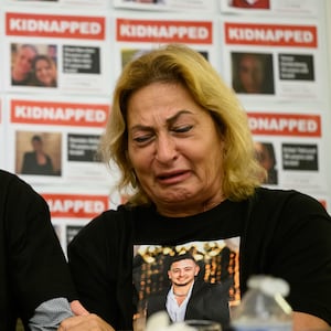 Thomas Hand, left, the father of Emily Hand, listens to Orit Meir, the mother of Almog Meir, as she addresses journalists during a press conference at the Embassy of Israel, London, on November 20, 2023.