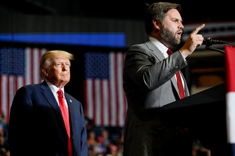 Former U.S. president Donald Trump listens as JD Vance speaks during a rally in Youngstown, Ohio, U.S., September 17, 2022.