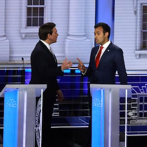 Republican presidential candidate Vivek Ramaswamy (C) talks to fellow candidate Florida Gov. Ron DeSantis and U.S. Sen. Tim Scott (R-SC) during a break in the NBC News Republican Presidential Primary Debate