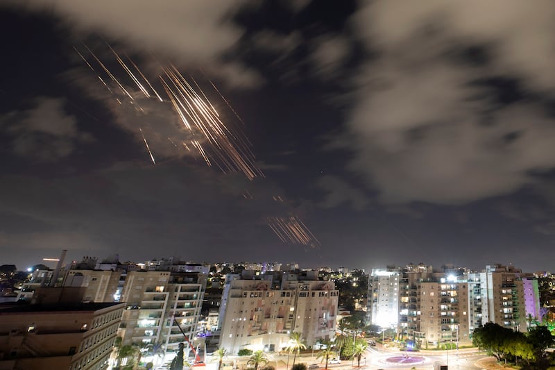 Israeli defense systems intercepts missiles at night.