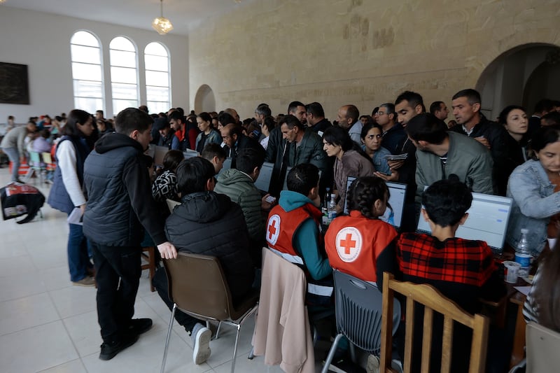 Red Cross workers help refugees at Goris theater.