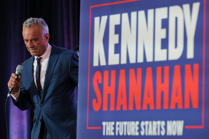 Robert F. Kennedy Jr holds a microphone on stage 