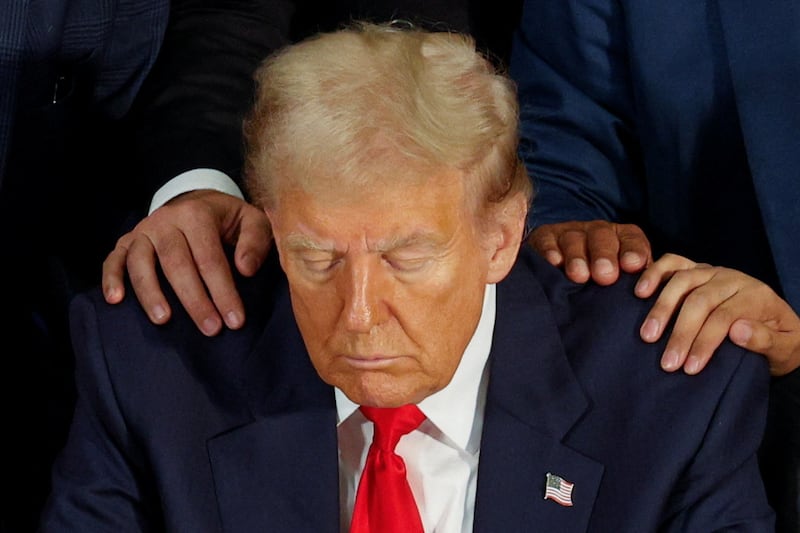 Hands on Donald Trump’s shoulder while praying.