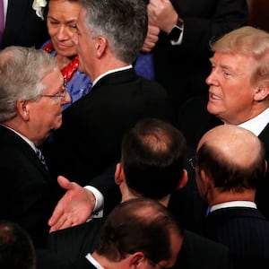 Donald Trump talks with U.S. Senate Majority Leader Mitch McConnell and Senate Majority Whip John Cornyn (L) after delivering his State of the Union address