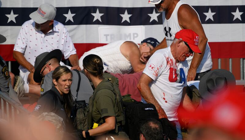 Attendees scatter after gunfire rang out during a campaign rally for Republican presidential candidate