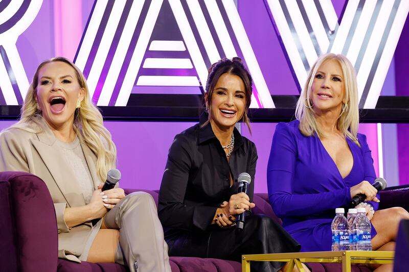 Heather Gay, Kyle Richards and Vicki Gunvalson on a couch laughing at Bravocon