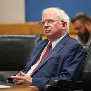 John Eastman sits with his hands crossed in a courtroom.