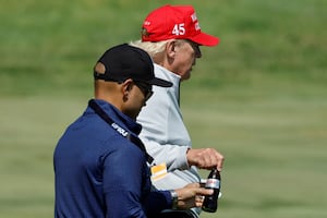 Walt Nauta, personal aide to former U.S. President Donald Trump, hands his boss a Diet Coke on the golf course.