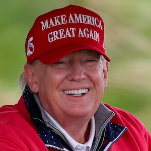 Donald Trump smiles while golfing.