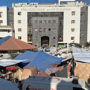 People, including Palestinian children, who fled their house due to Israeli strikes, gather at Al Shifa hospital.