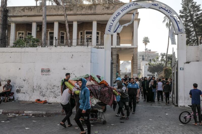 Palestinians carried items salvaged from the heavily damaged Al-Ahli Baptist Hospital in Gaza City.