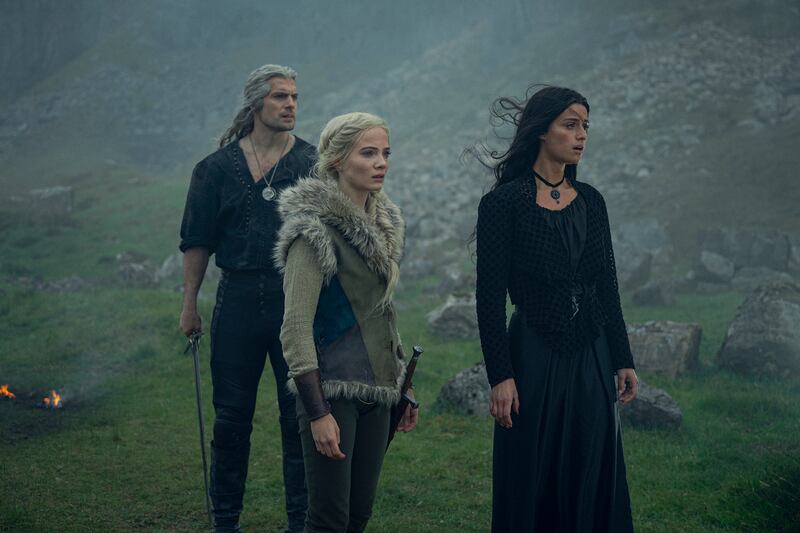 A production still of Henry Cavill, Freya Allan, and Anya Chalotra in the third season of The Witcher.