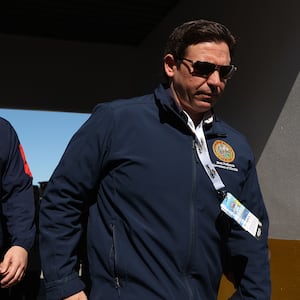 Florida Gov. Ron DeSantis, with a lanyard around his neck, walks at the Daytona 500.