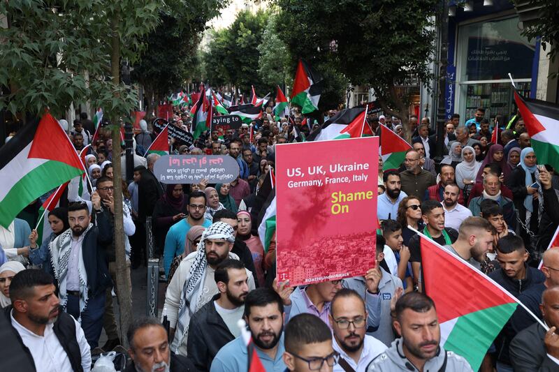 A photo including Palestinians waving the national flag in the West Bank city in Ramallah 