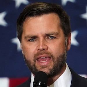 JD Vance speaks in front of an American flag.