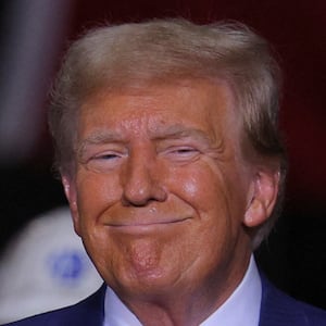 Donald Trump smiles while on stage at a campaign event. 