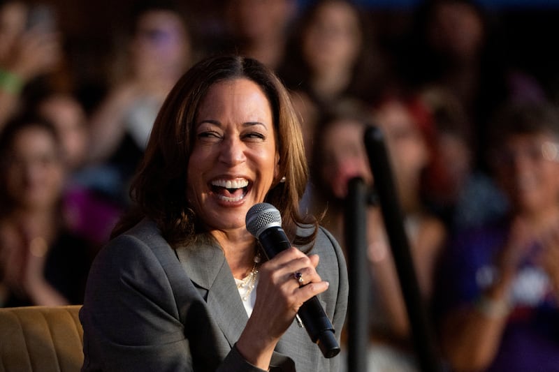 Kamala Harris holding a microphone laughing