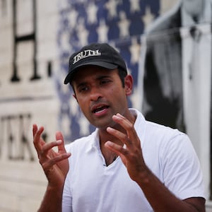 Republican presidential candidate Vivek Ramaswamy answers questions from reporters beside his campaign bus in Contoocook, New Hampshire.