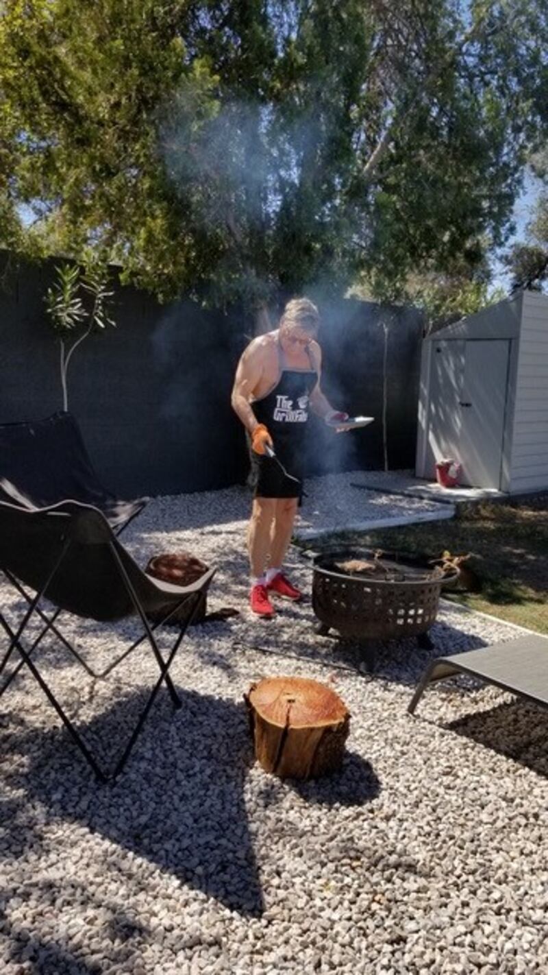 A photo of Max Dufloo in an apron, barbecuing.