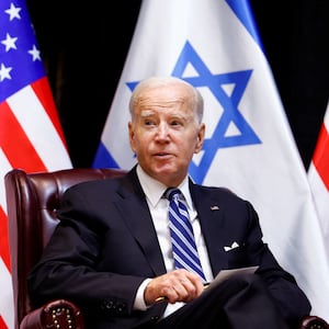 President Joe Biden sits in front of Israeli and American flags.