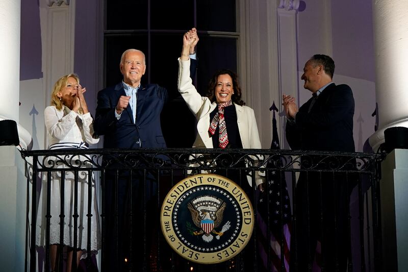 Joe Biden and Kamala Harris raise their hands as they stand on a White House balcony with first lady Jill Biden and second gentleman Doug Emhoff during an Independence Day celebration in Washington, U.S., July 4, 2024.