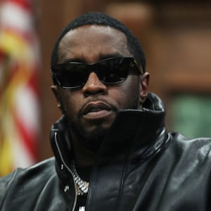 Sean Combs, wearing sunglasses, sits in a courtroom.