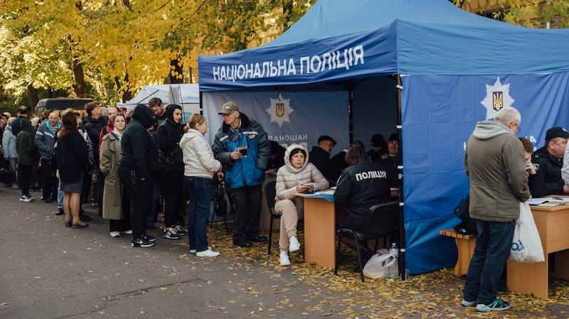 Police members provide assistance to victims of the Russian missile attack