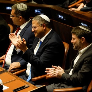 Itamar Ben-Gvir and Bezalel Smotrich sit and clap at a special session at the Knesset.