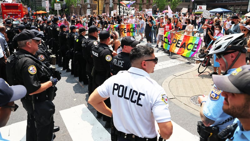 A photo that includes Philadelphia Police Officers as people Protest the Moms for Liberty of Joyful Warriors National Summit outside the Philadelphia Marriott Downtown.