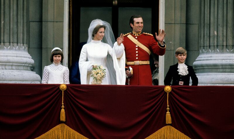 Princess Anne, Princess Royal and Mark Phillips wave from the balcony of Buckingham Palace following their wedding with Prince Edward, Earl of Wessex (R) on November 14, 1973 in London, England.