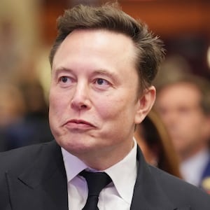 Elon Musk listens as U.S. President-elect Donald Trump addresses a House Republicans Conference meeting at the Hyatt Regency on Capitol Hill on November 13, 2024 in Washington, DC.