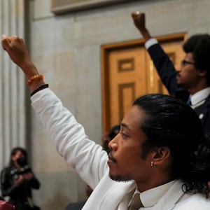 Rep. Justin Pearson and Rep. Justin Jones raise their fists 